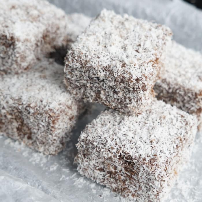 Chocolate lamingtons on a baking tray.