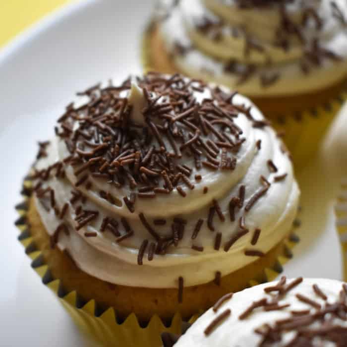 Baileys cupcakes on a white plate with a yellow background