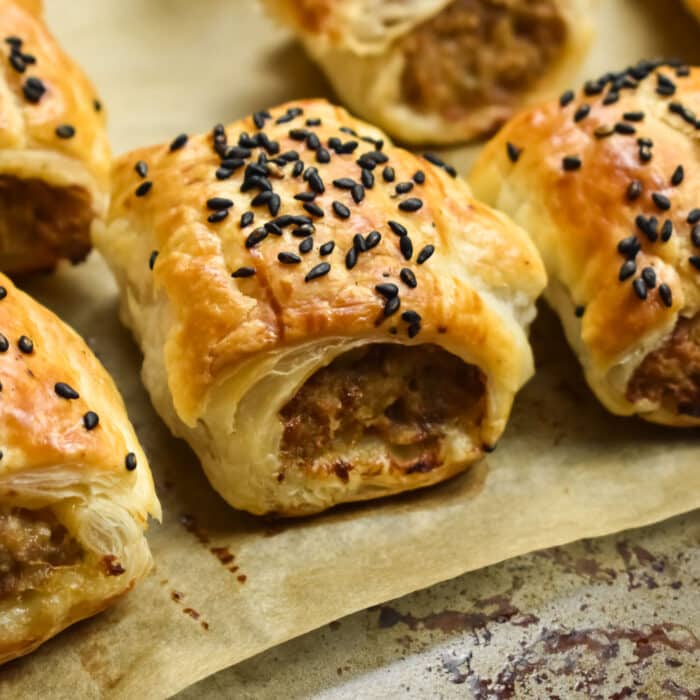 Rosemary sausage rolls on a baking tray